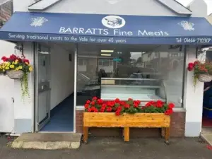 The Barratts Fine Meats shopfront in Rhoose, with hanging baskets and a new serve-over counter visible through the window