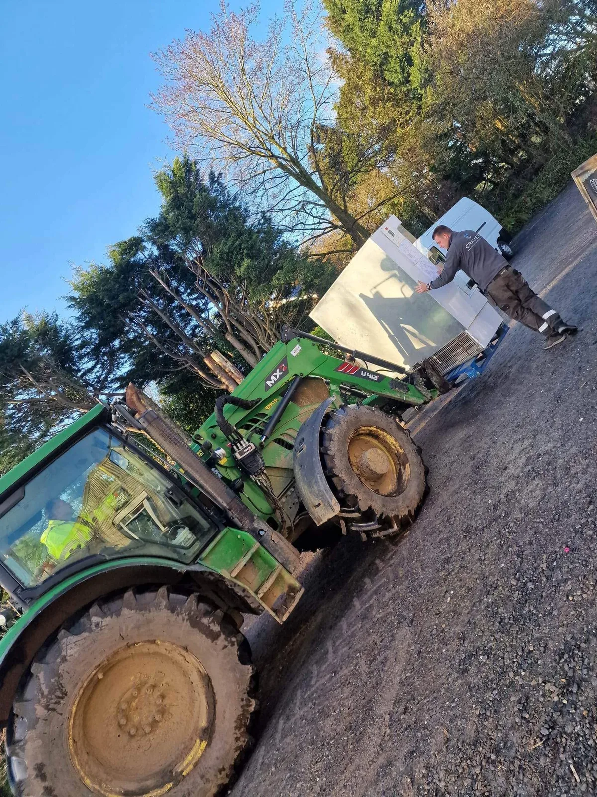 The old refrigerated cabinet raised on a tractor's forks outside the farm shop, ready to be moved to a barn