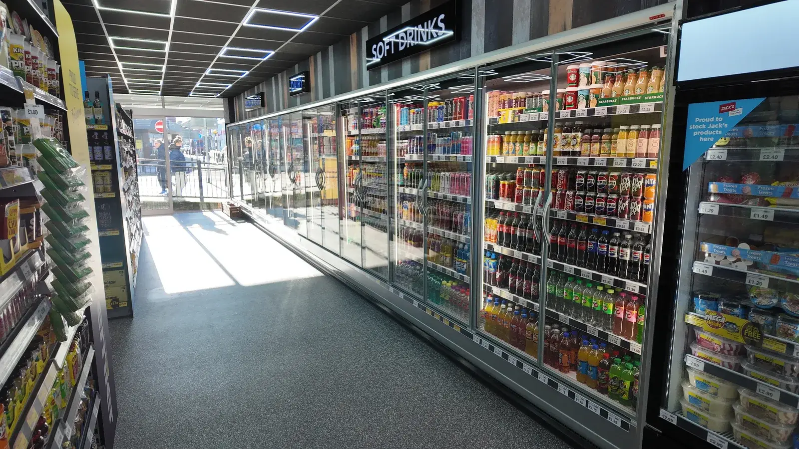 The new Aria's Hub sales floor in Bridgend — full-length refrigerated aisle glowing under new lighting